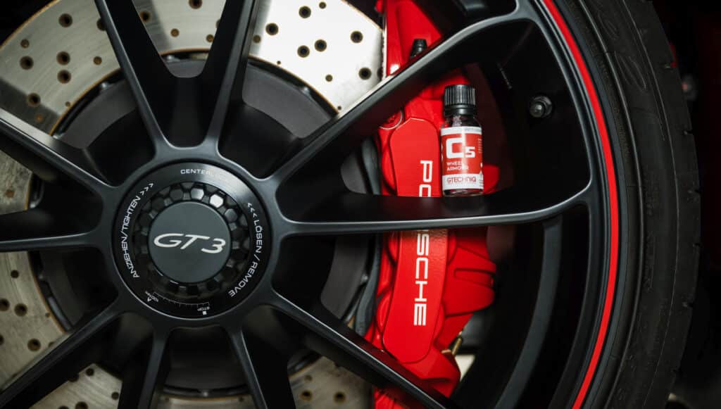 this image shows a Porsche GT3 wheel with a bottle of Gtechniq Wheel Armour ceramic coating sitting next to the wheel caliper